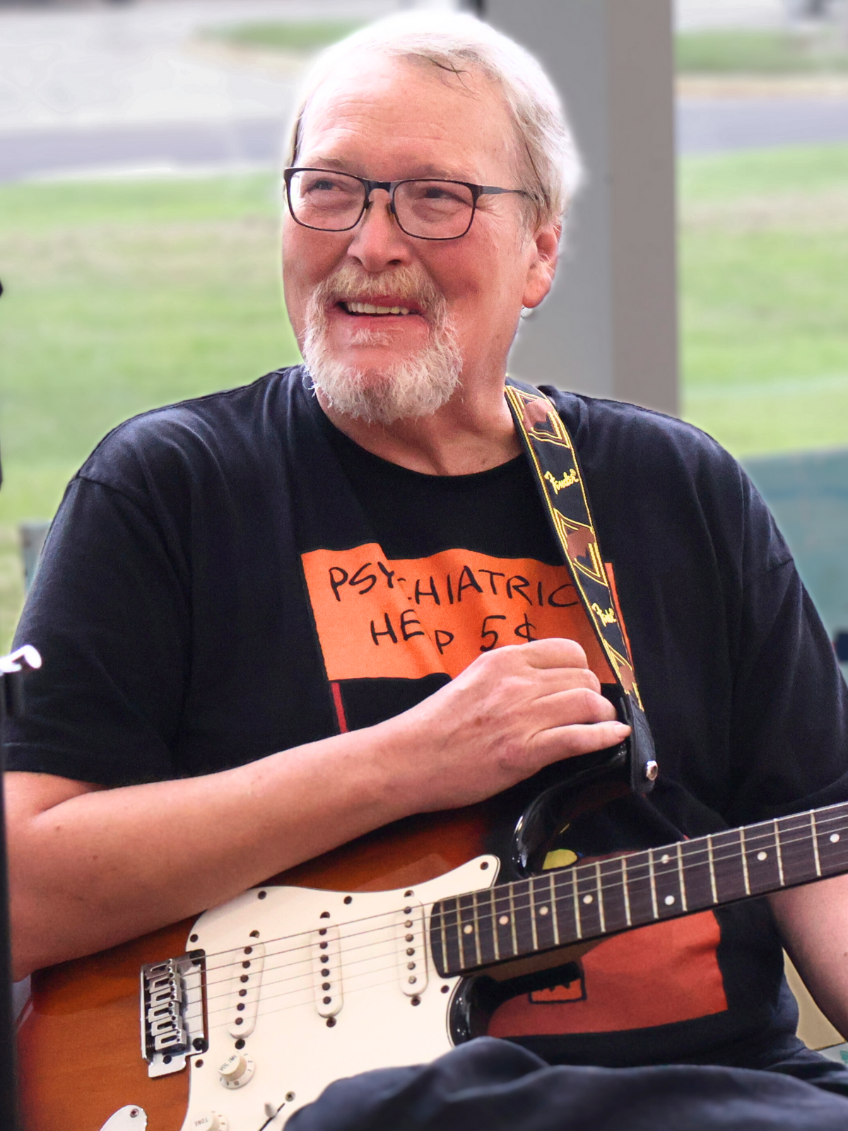 Smiling man playing guitar during a Crossroads Community and Corsica River client activity