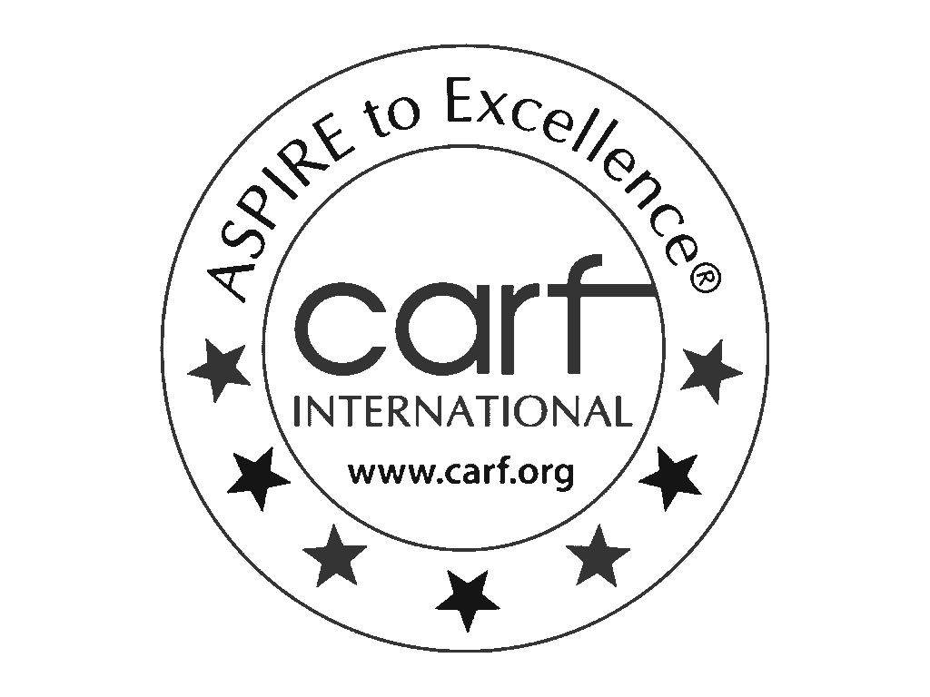 CARF International accreditation seal with Aspire to Excellence motto and stars around the logo