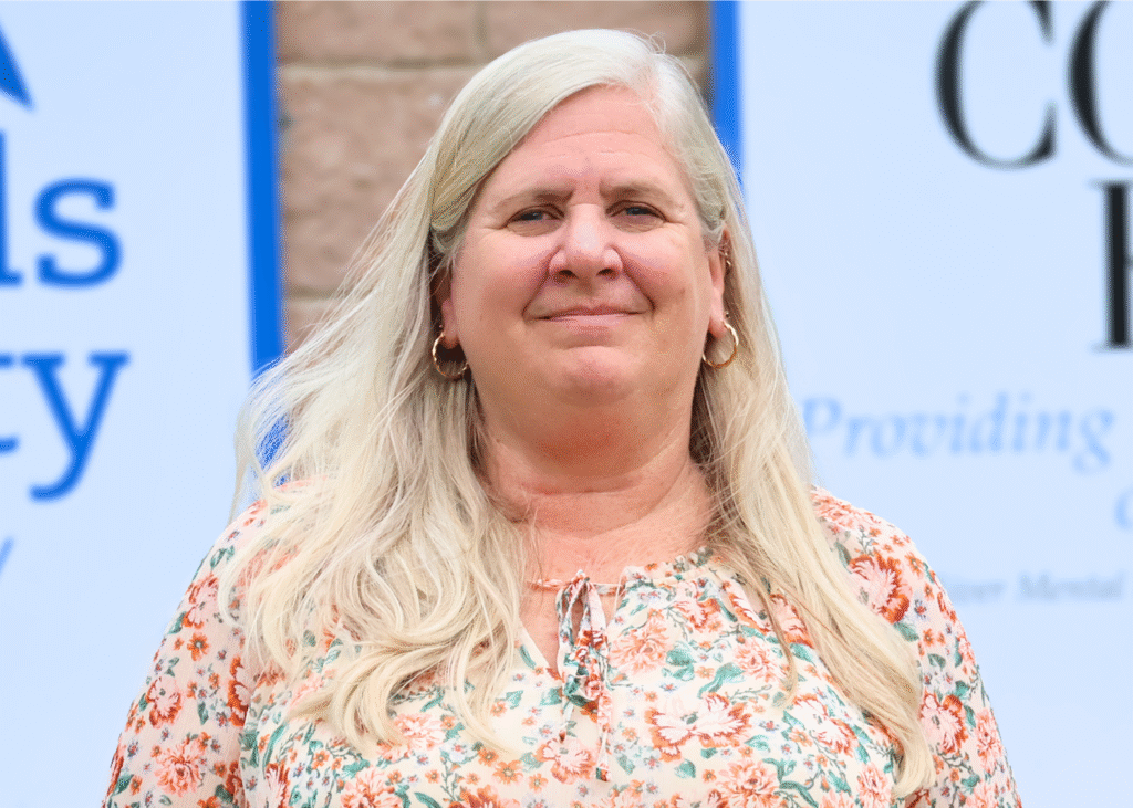 Paula Turner, Clinical Director at Corsica River Mental Health Services, smiling in front of organizational signage.